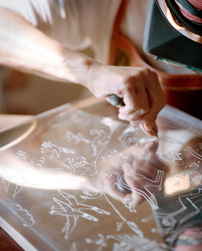 Närbild på en gravör i arbete.