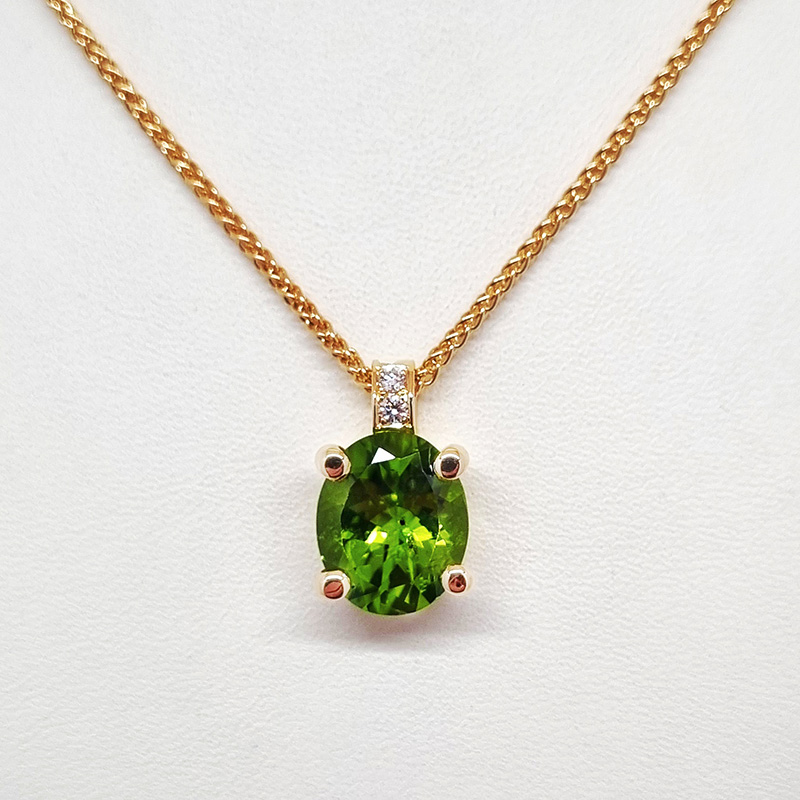 Guldhalsband med hänge i grön peridot och diamant.